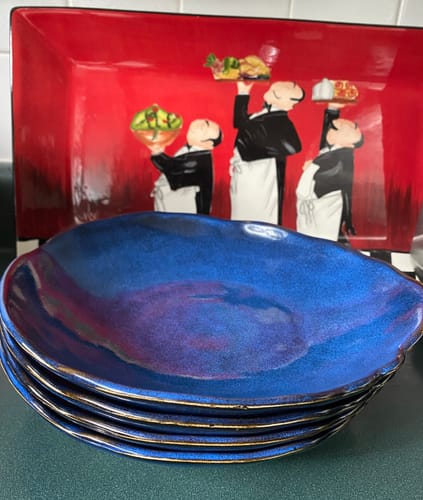 Customer's stack of four Organic Deep Bowls in shiny Ocean Blue, showing their wavy edges and deep design.