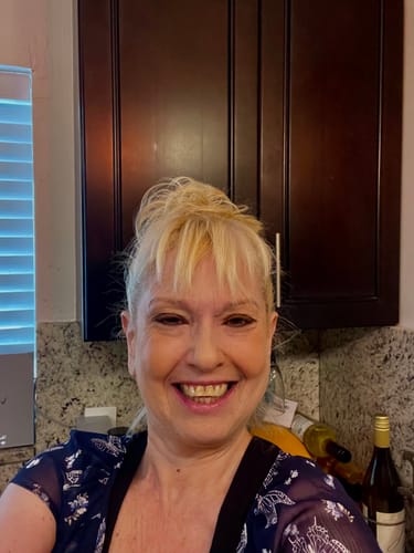 Customer smiling while wearing the blonde JuvaBun Small Messy Bun in a top knot style.