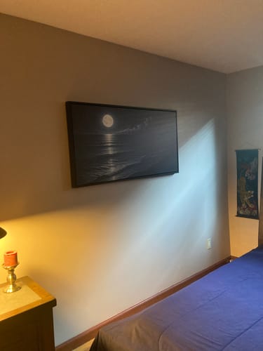 Customer's framed Beach Shoreline Coastal Wall Art with a dark, moonlit ocean scene, hung in a bedroom.
