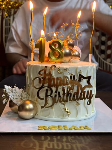 Customer's white Customized Flower Cake with gold '18' candles and a 'Happy Birthday' topper.