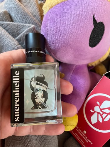 Reviewer holding the square Fart Kitten perfume bottle in their hand.