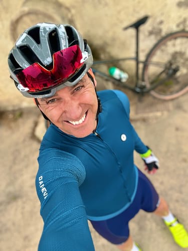 A smiling reviewer wearing the blue LIFTTINT LS JERSEY and a helmet while out for a ride.