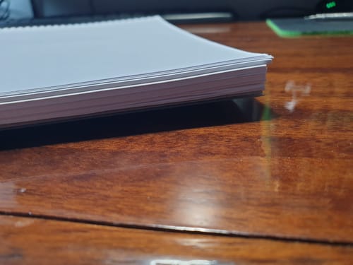 Gros plan d'un client sur les pages ondulées du bloc-notes Easynotes, posé sur un bureau.
