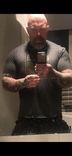 Customer takes a mirror selfie showing their muscular physique for their Liquid L-Carnitine review.