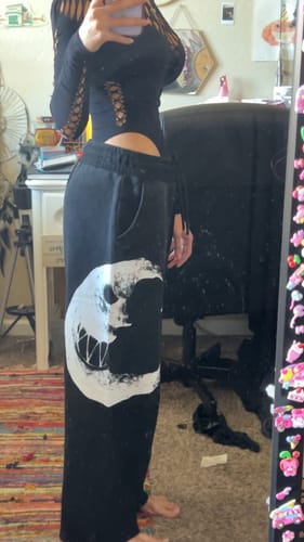 Reviewer wearing the black SUNNY & LUNA LOUNGE PANTS, showing the fit and large white moon graphic on the leg.