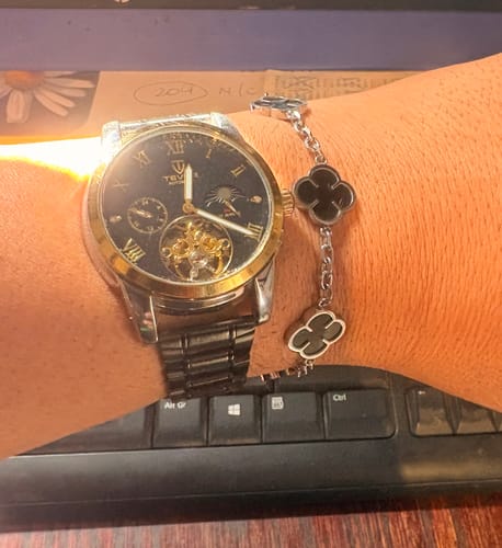 Cliente mostrando la Pulsera Black Clover en su muñeca, junto a un reloj.