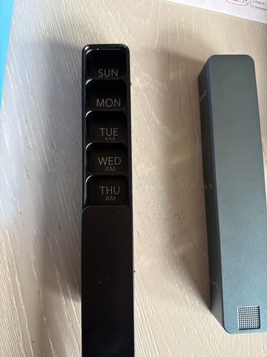 Customer's black Weekly AM-PM Pill Case 2.0 shown with the daily organizer and the separate grey metal case.