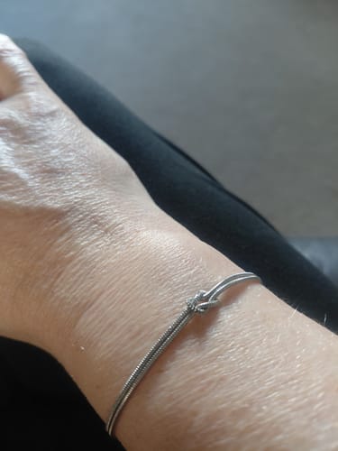 Close-up of a customer's wrist wearing the silver-colored Forever Knot Bracelet.