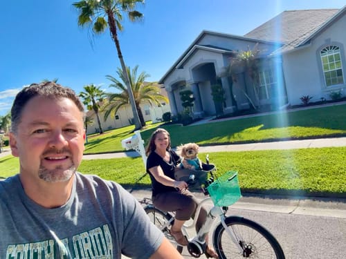 Reviewers on a sunny bike ride with their small dog sitting in the Kvisp Dog Bike Carrier.
