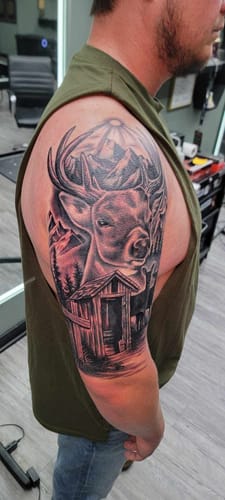 Customer's arm showing a detailed half-sleeve tattoo of a deer, done with Painless Tattoo Numbing Cream.