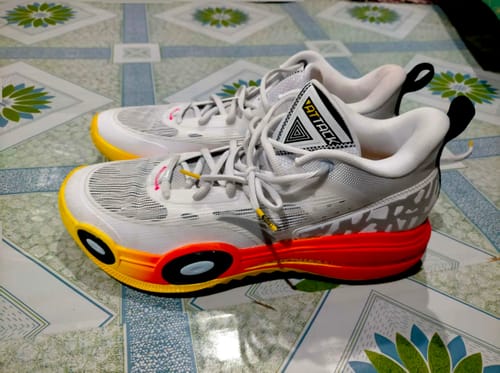 Customer's pair of white ANTA Shock The Game Attack 6 shoes, showing the colorful red, orange, and yellow sole.
