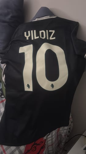 Recensore mostra il retro della sua Maglia Third Juventus nera, personalizzata con il nome Yildiz e il numero 10.