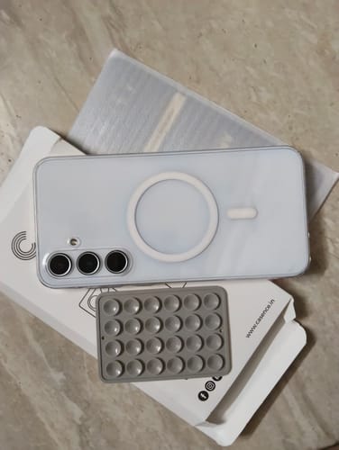 Customer's grey StickyPod suction mount shown next to a smartphone and product packaging.