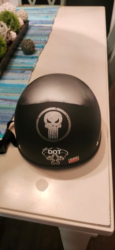 Customer's black beanie helmet on a table, showing the back view with the skull logo and DOT sticker.