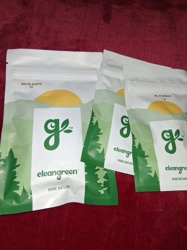 Customer's pouches of cleangreen products, including White Runtz, laid out on a red surface.