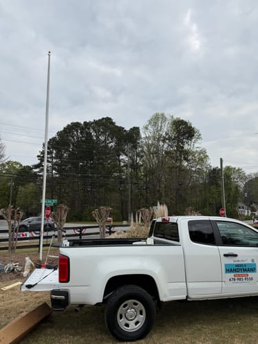 Customer's installed Ultra Heavy-Duty Home Flagpole viewed from beside a white work truck.