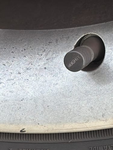 Close-up of a customer's dark 80Eighty® Valve Stem Cap installed on a wheel.