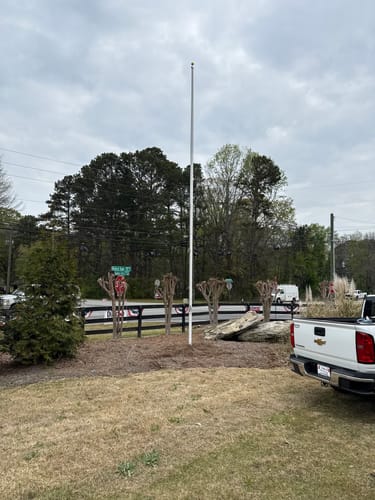 Customer's newly installed Ultra Heavy-Duty Home Flagpole in a landscaped yard area.