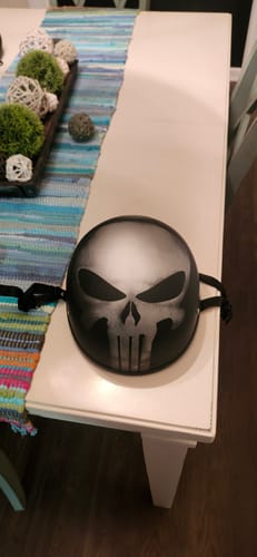 Reviewer's black beanie helmet on a table, showing the front view with the large skull graphic.