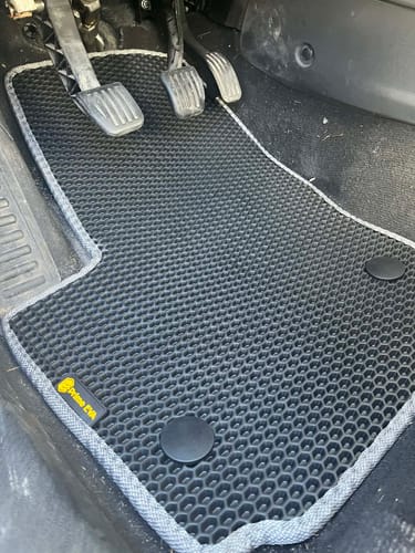 Recenzenta czarny, dopasowany dywanik samochodowy zamontowany po stronie kierowcy.