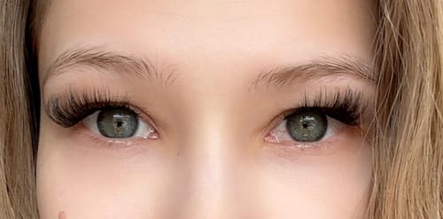 Kundin zeigt eine Nahaufnahme ihrer Augen mit den voluminösen Pretty Press Pre-Glued Wimpern im Cateye-Look.