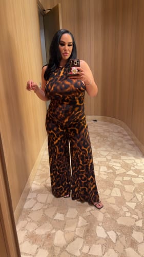 Reviewer taking a mirror selfie while wearing the leopard print halter wide leg jumpsuit.