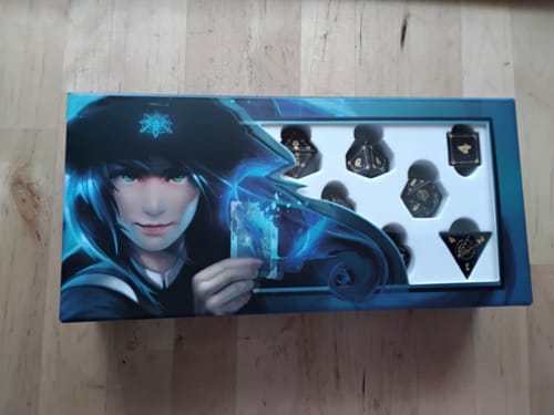 Reviewer's Blue Sandstone Dice Set in its pristine illustrated box, showing the dice through a window.