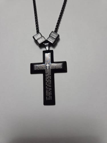 Customer's black Legacy necklace with a cross pendant and two beads. The engraving on the pendant is visibly small.