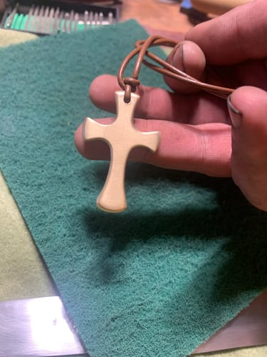 Customer holding a small finished cross over the green Non-Woven Hand Pad.