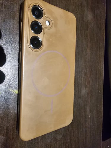Close-up of a customer's brown Magsafe case on a Samsung S25, showing the camera and faint charging ring.