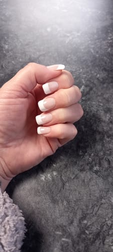 Customer's hand showing a neat French manicure created with the Holy Gels Starter Kit.