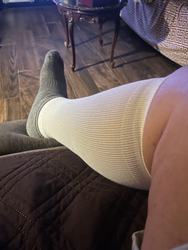 Customer resting their leg while wearing a white Performance Eucalyptus Compression Sock.