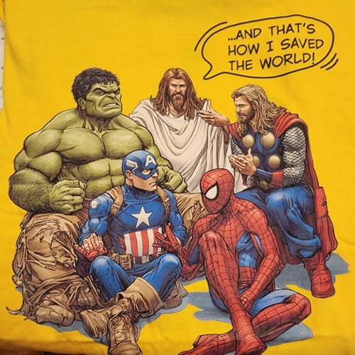Reviewer's yellow 'How I Saved The World' shirt with a graphic of Jesus sitting with Marvel superheroes.