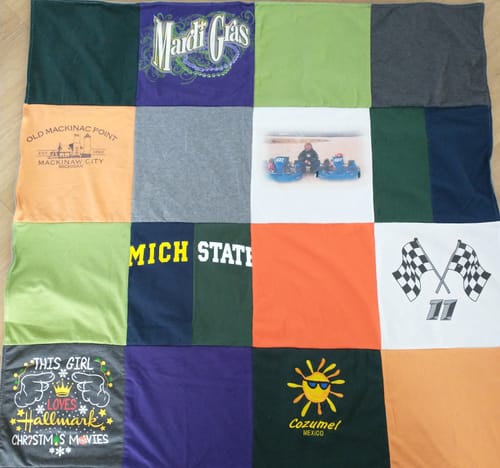 Customer's colorful Project Repat T-Shirt Quilt laid out, made from a grid of personal t-shirt squares.
