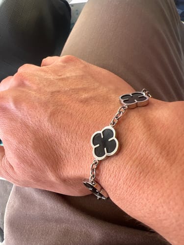 Cliente mostrando su Pulsera Miami Cuban 5mm en la muñeca, con un pantalón marrón de fondo.