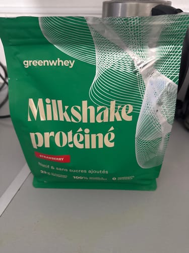 Photo d'un client montrant le sachet vert de Milkshake protéiné goût fraise.