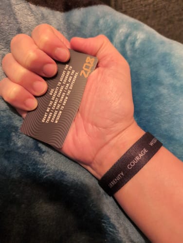 Reviewer wearing the black Serenity Courage Wisdom Bracelet and holding the matching Serenity Prayer card.