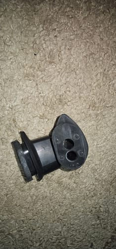 Customer's close-up of a black rubber OEM part for the Honda Africa Twin tail tidy, lying on a carpet.