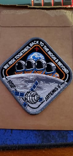 Customer's embroidered Artemis II Collectors Patch shown on a cardboard mailer.