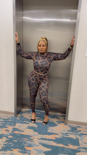 Reviewer posing in an elevator showing the full-body fit of the Naked Print Stirrup Jumpsuit.