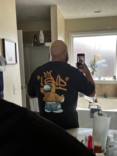 Customer in a mirror showing the back graphic of the 720S Tagger Bear Tee.