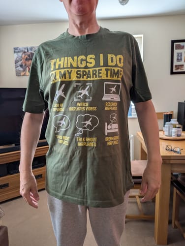 Reviewer wearing the green Things I Do Planes T-Shirt, showing the humorous airplane-themed graphic.