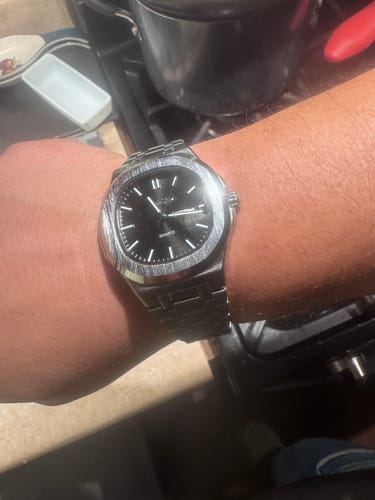 Reviewer's wrist showing the Lucky Fours® Brone watch with a silver-toned case and a black dial.