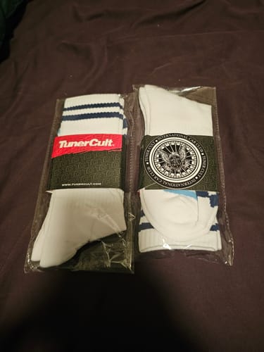 Customer's two new pairs of M-POWER SOCKS in their original packaging, laying on a dark surface.