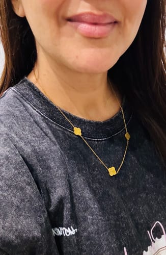 Close-up of a reviewer wearing the gold Sabr, Shukr, Tawakkul Necklace against a dark shirt.