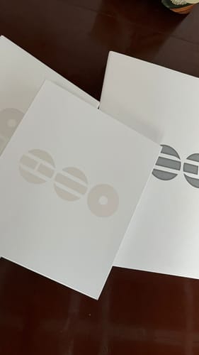 Customer's BTS Arirang albums showing the different white packaging versions fanned out on a table.