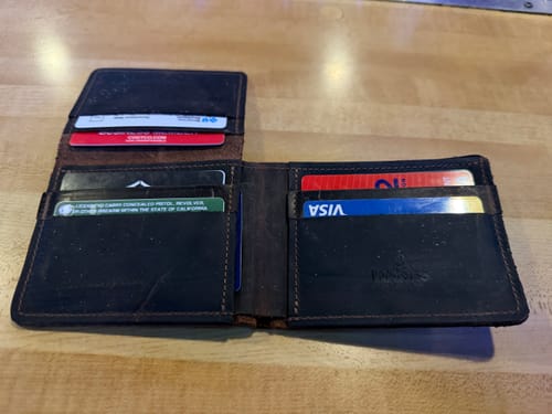 Customer's open Huron Premium Bifold with ID Window filled with cards on a table.