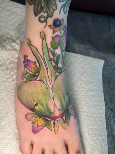 Customer showing their colorful, completed foot tattoo after using Painless Tattoo Numbing Cream.