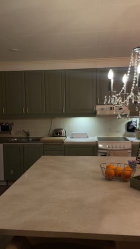 Kundes kjøkken med en ny kjøkkenøy dekket med Emmy beige kontaktplast i en varm, lys farge.