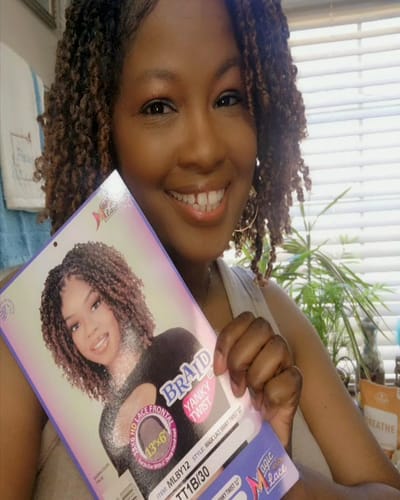 Reviewer wearing the Chade Magic Lace Braid Wig in Yanky Twist style while holding the product packaging.